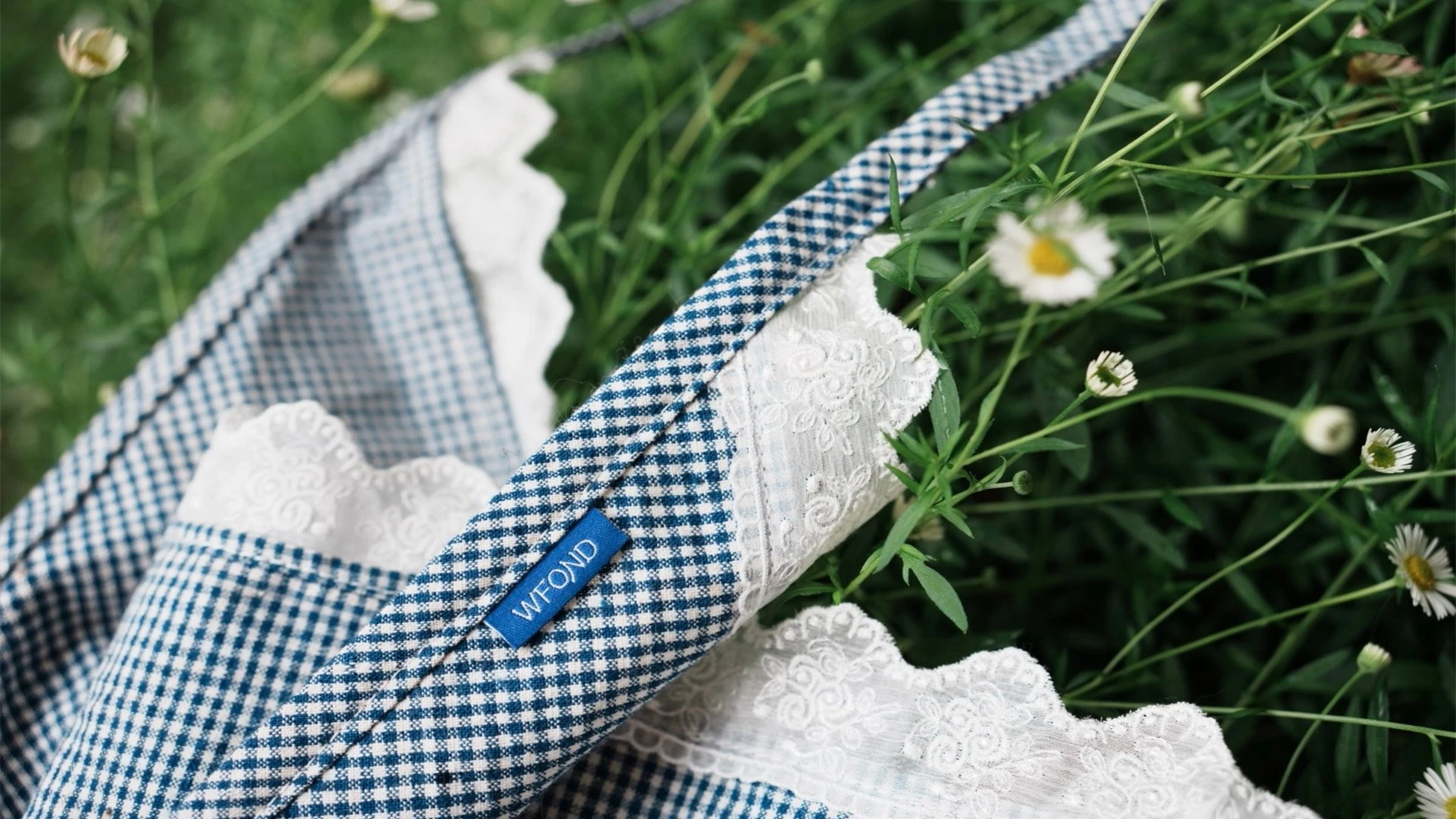A WFOND gingham headscarf resting on spring grass